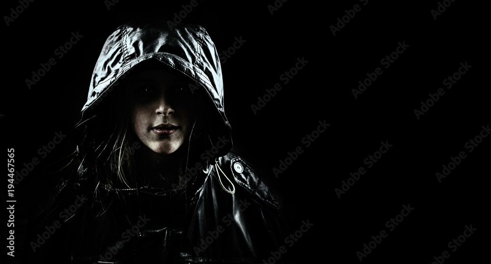 Mysterious girl in a hood on a black background. Stock Photo | Adobe Stock