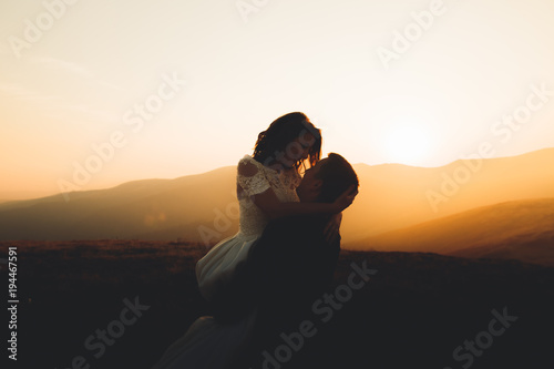 Wedding couple posing on sunset at wedding day. Bride and groom in love