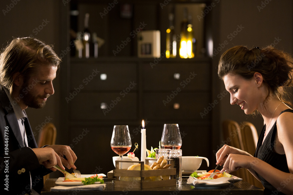 Man and woman eating during candlelight lunch.Couple in love romantic dinner at restaurant Man and woman eating during candlelight lunch.Couple in love romantic dinner at restaurant