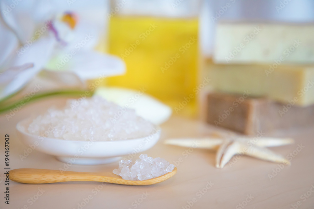 Wellness setting. Sea salt, soap, towel, oil and flowers on wooden background, spa Wellness setting. Sea salt, soap, towel, oil and flowers on wooden background, spa
