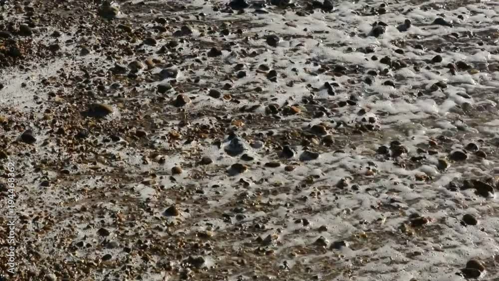 Small waves breaking onto shingle and sand beach Small waves breaking onto shingle and sand beach