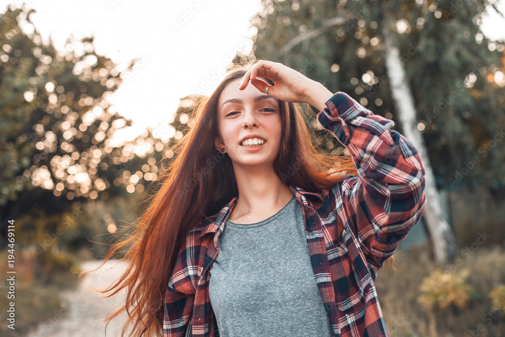A young woman in checkered shirt is walking outdoors. A young woman in checkered shirt is walking outdoors.