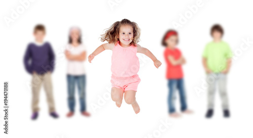 The little one of the family jumping and her brothers in the background isolated on white © Gelpi