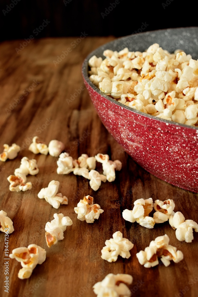 Popcorn in a frying pan on a wooden table Popcorn in a frying pan on a wooden table