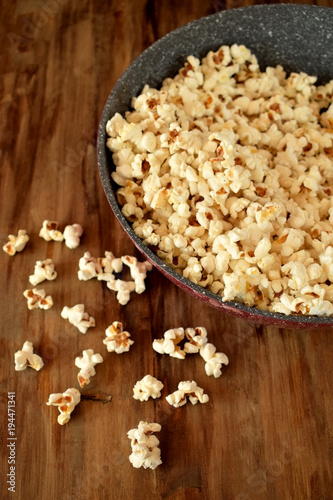 Popcorn in a frying pan on a wooden table