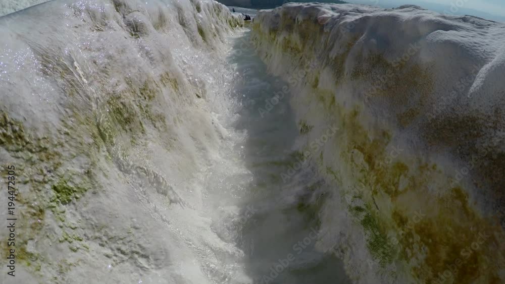 Blue water flows down stream in travertine in Pamukkale. 