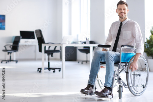 Young man in wheelchair at workplace