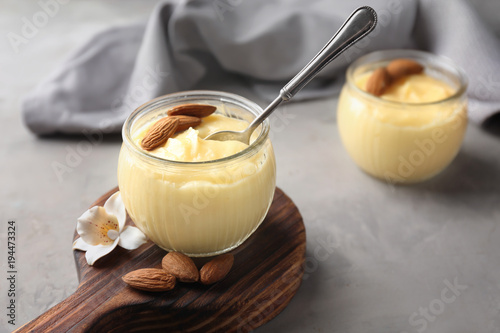 Glass jar with vanilla pudding with almond on table photo