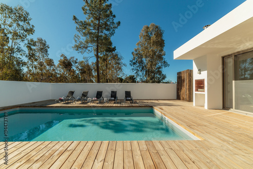 Modern house with garden swimming pool and wooden deck