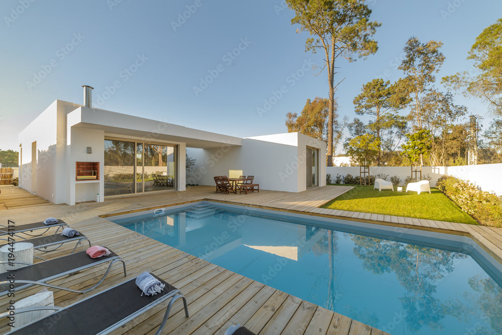 Modern house with garden swimming pool and wooden deck - obrazy, fototapety, plakaty 
