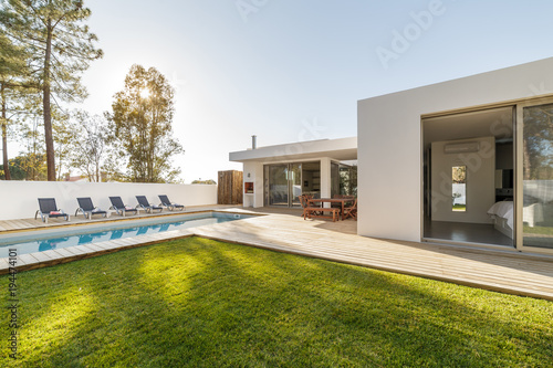 Modern house with garden swimming pool and wooden deck