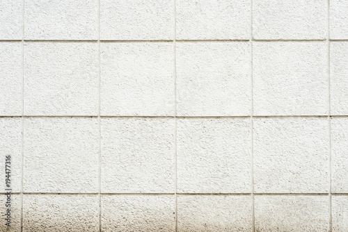 Deep texture of a white painted porous stone on the facade of the building. Finishing the facade of the building into square sections. Texture background with stone wall