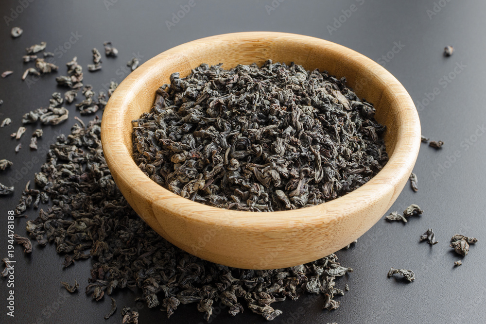 black tea leaves in a wooden bowl black tea leaves in a wooden bowl