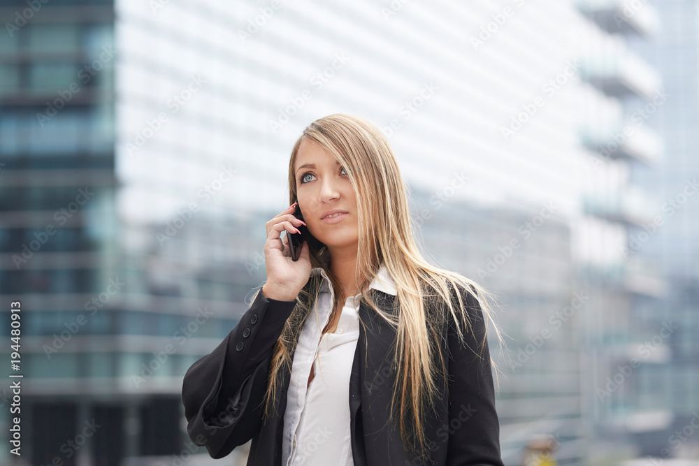 businesswoman talking to mobile in urban environment businesswoman talking to mobile in urban environment
