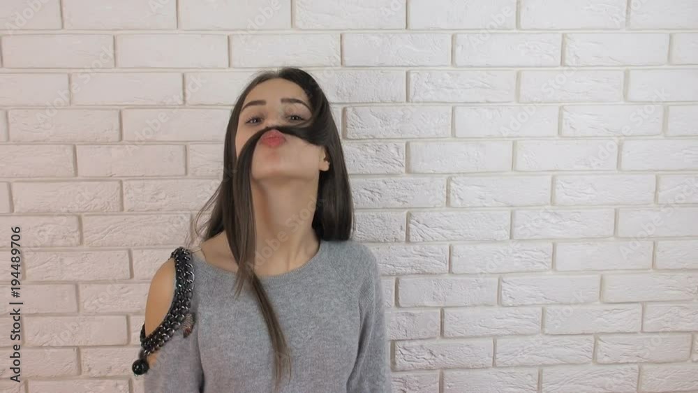 A teenager with a mustache. A funny girl makes herself a mustache. A teenager with a mustache. A funny girl makes herself a mustache.