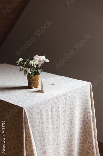 Card next to flowers on a table photo
