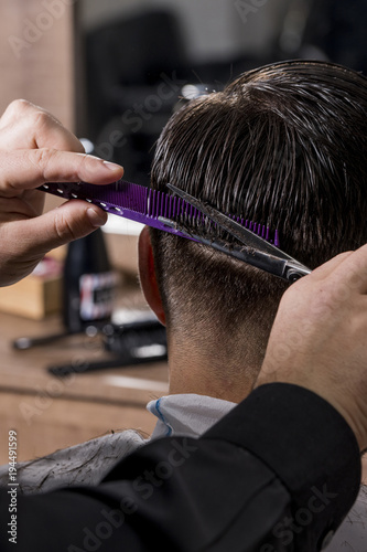 Hairdresser cutting a client's hair with scissors