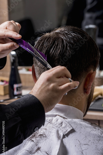 Hairdresser cutting a client's hair with scissors © fresnel6