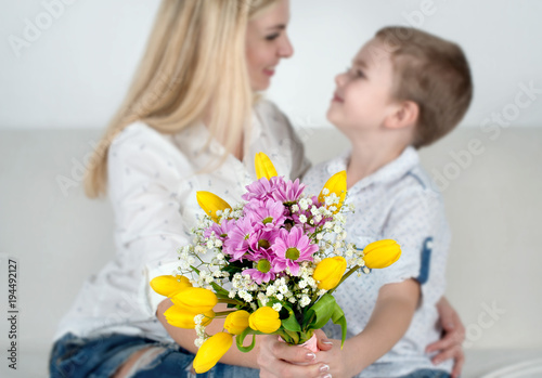 Son gives his beloved mother a beautiful bouquet of tulips.The concept of the celebration,women's day.	