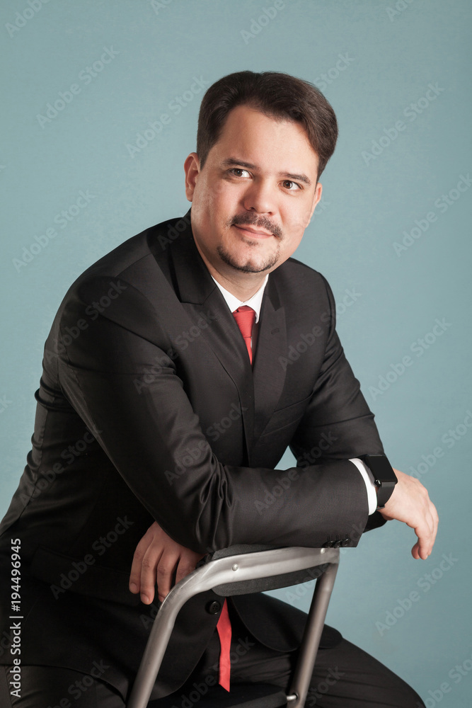 Portrait of acting shoot sitting businessman, little smile on face Portrait of acting shoot sitting businessman, little smile on face