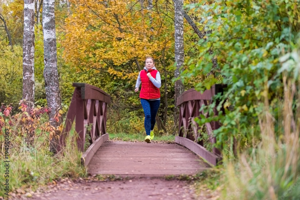 A girl runs in the forest on the shore of the pond