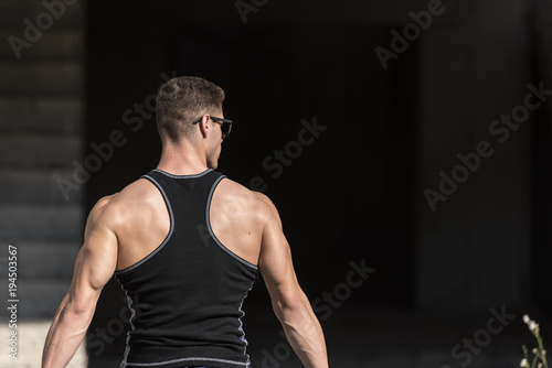Back of a very trained man, wear a high quality workout shirt
