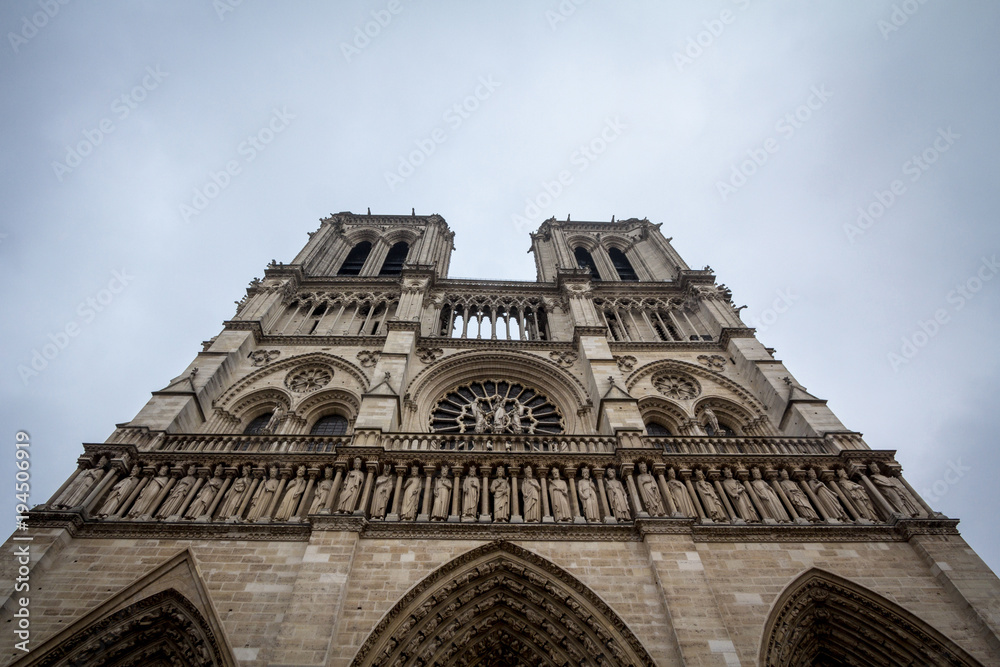 Notre Dame de Paris Cathedral in Paris, France, taken from the bottom during a grey afternoon. This medieval gothic cathedral is one of the main monuments of the capital city of France