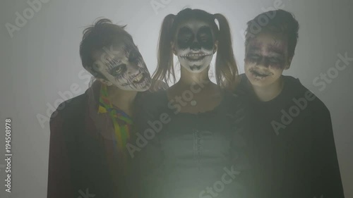 Malefic group of zombies woken up on halloween day of the dead laughing crazy and threatening surrounded by smoke photo