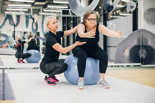 Senior woman exercising with personal trainer