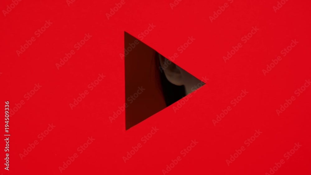 Girl's face appears and hides in triangular hole of paper red background. Bright makeup in front of woman. Girl peeks into the lock well. Button play. Conception advertising cosmetics.
