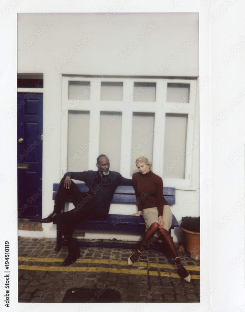 Stylish couple sitting on bench. Stylish couple sitting on bench.
