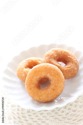 Homemade sugar donut on white dish