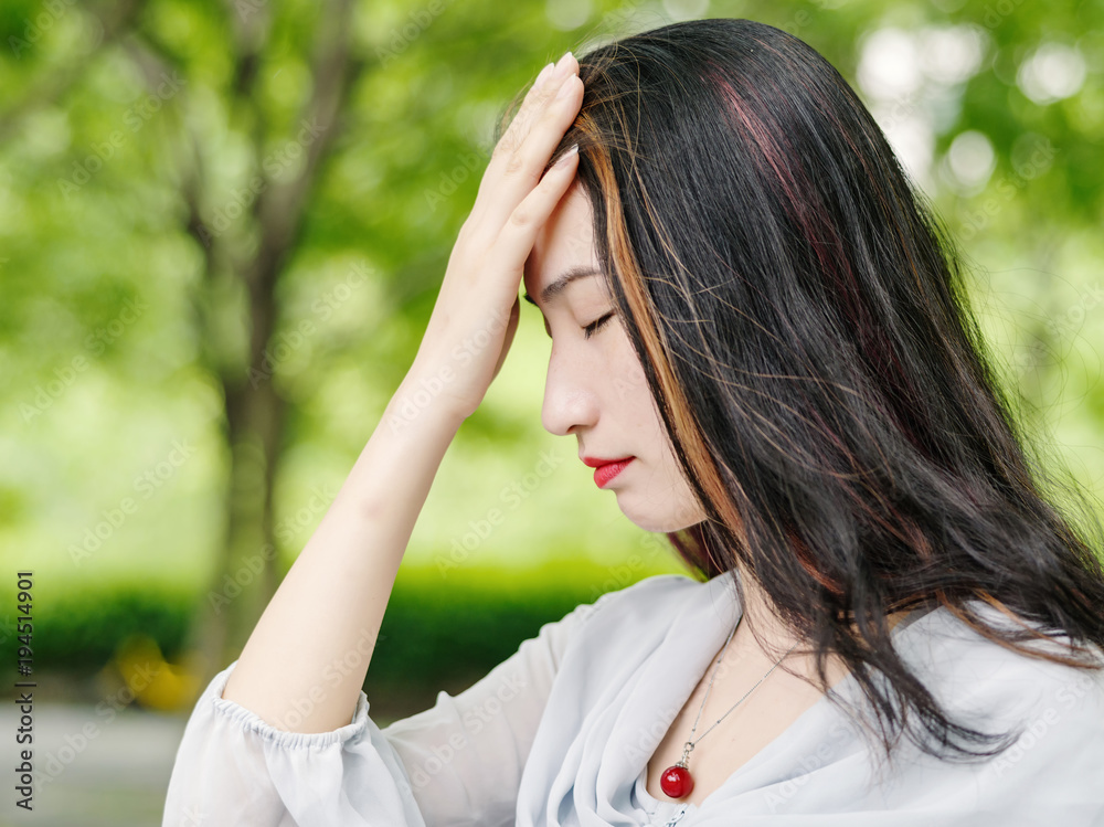 Beautiful young brunette woman make depression gesture with hand on her head. Outdoor fashion portrait of glamour young Chinese stylish lady. Emotions, people, beauty and lifestyle concept. Beautiful young brunette woman make depression gesture with hand on her head. Outdoor fashion portrait of glamour young Chinese stylish lady. Emotions, people, beauty and lifestyle concept.