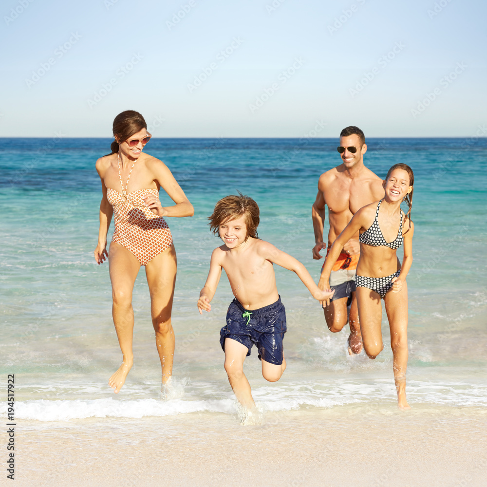Family running on the beach on vacation in Mexico Family running on the beach on vacation in Mexico