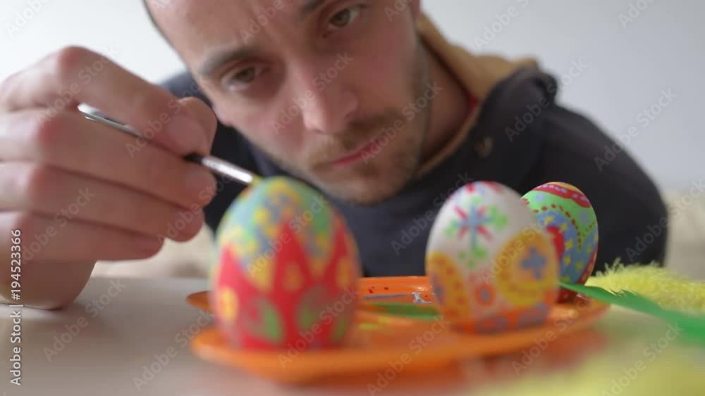 Man paints the Easter eggs. Easter painting.Man decorating colorful eggs. Man paints the Easter eggs. Easter painting.Man decorating colorful eggs.