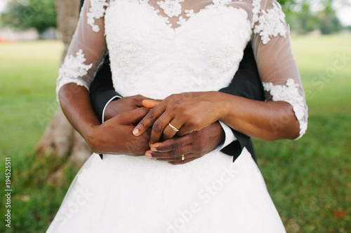 Just married! Clasped hands with wedding rings.