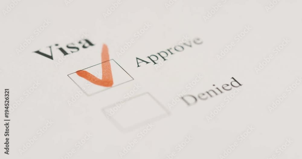 Close up of the visa application and hand making a tick with a red marker Approved. Macro shooting