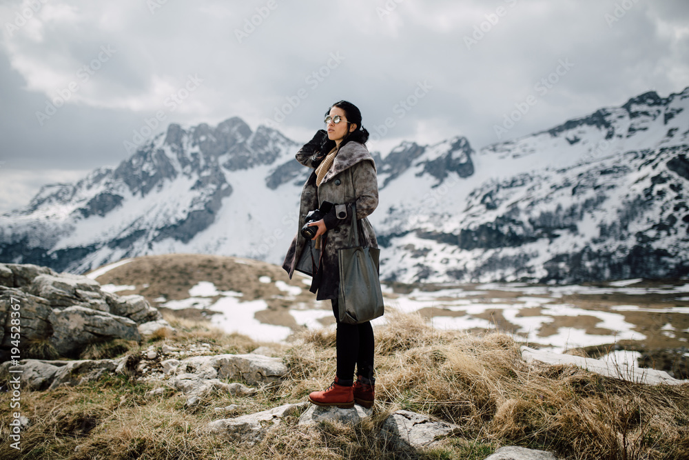 Portrait of a beautiful young woman in the mountain holding a camera Portrait of a beautiful young woman in the mountain holding a camera
