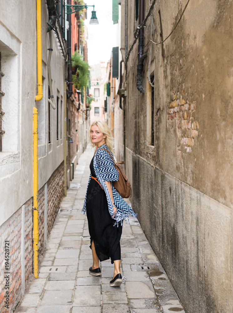 Young female walking down narrow street Young female walking down narrow street