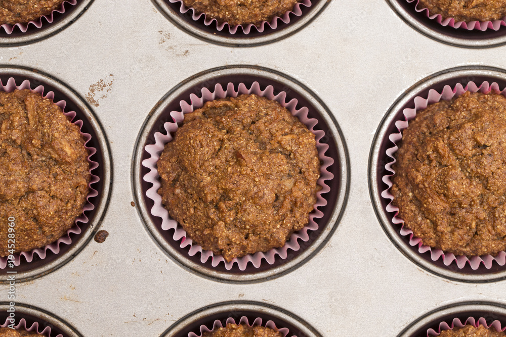 A Background of Apple Cinnamon Pecan Muffins in their Pan