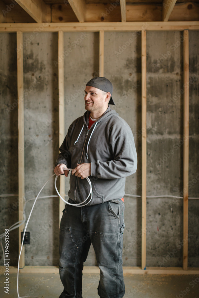 Electrician man installing wire on jobsite Electrician man installing wire on jobsite