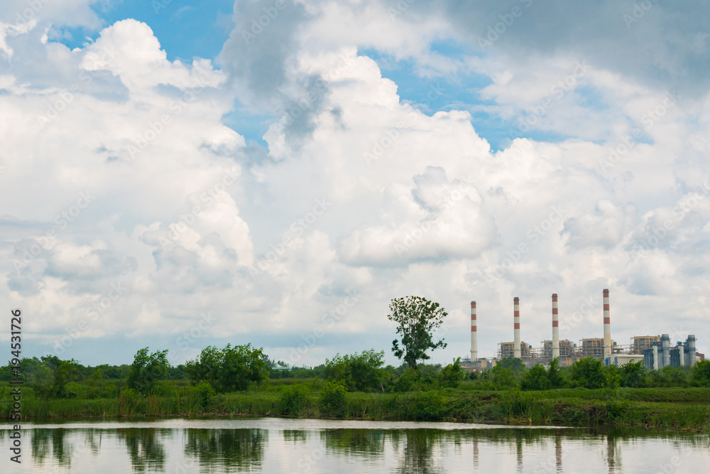 Power plant cooling tower with cloudy sky and reflection from the lake nearby Power plant cooling tower with cloudy sky and reflection from the lake nearby