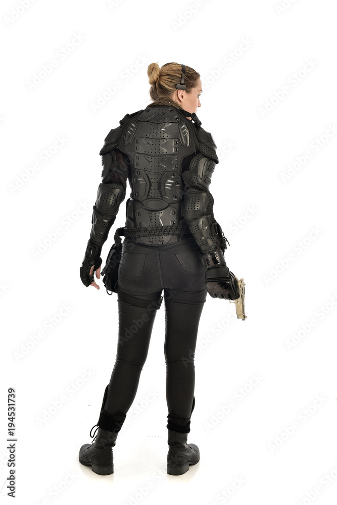 full length portrait of female soldier wearing black tactical armour, holding a gun, isolated on white studio background. full length portrait of female soldier wearing black tactical armour, holding a gun, isolated on white studio background.