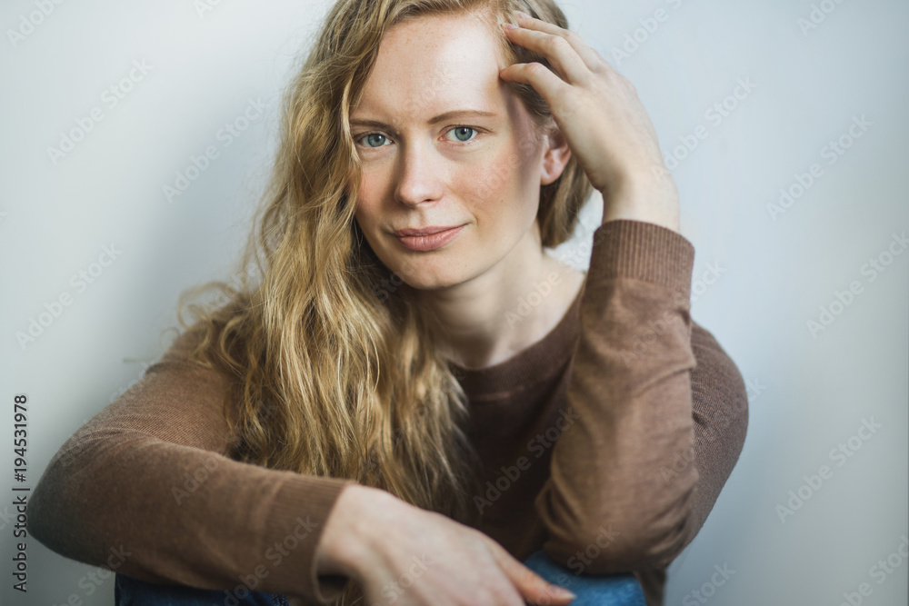 Simple portrait of a red headed woman sitting looking at camera Simple portrait of a red headed woman sitting looking at camera