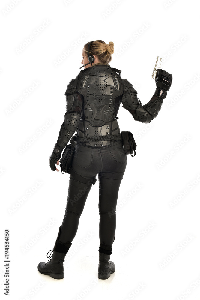 full length portrait of female soldier wearing black tactical armour, holding a gun, isolated on white studio background. full length portrait of female soldier wearing black tactical armour, holding a gun, isolated on white studio background.