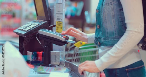 Customers buying food and staples from a cashier and paying at the till. Supermarket store. Close-up