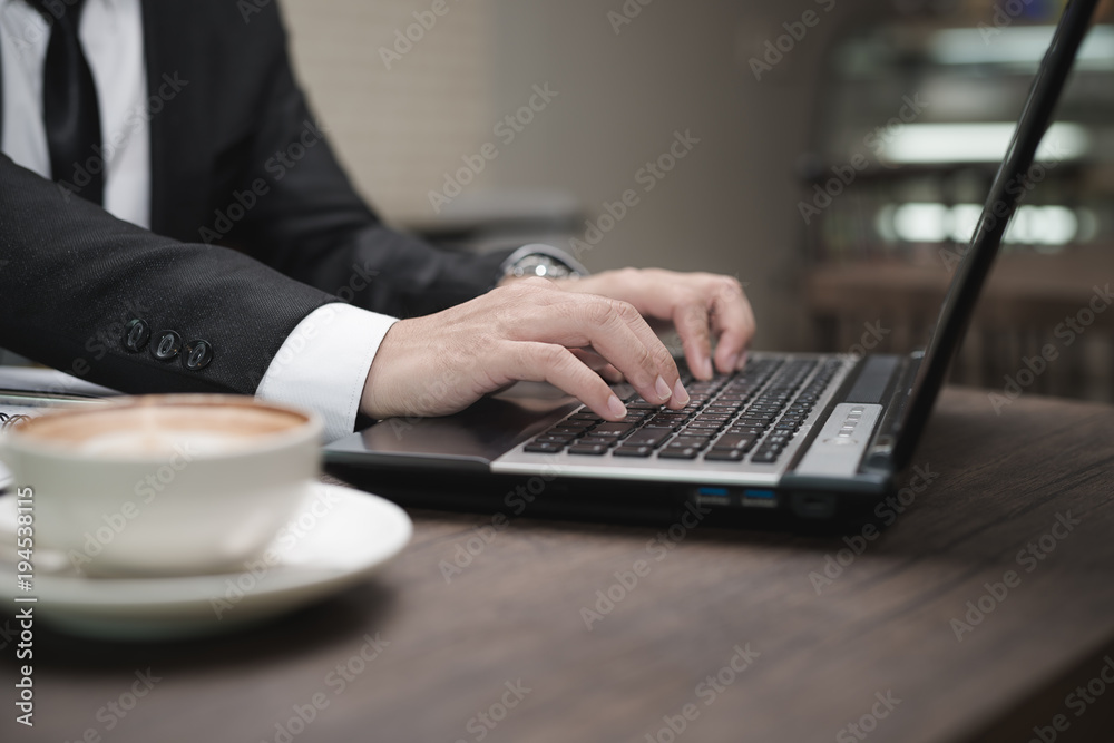 Young Asian businessman working with a laptop in a coffee shop. Young Asian businessman working with a laptop in a coffee shop.
