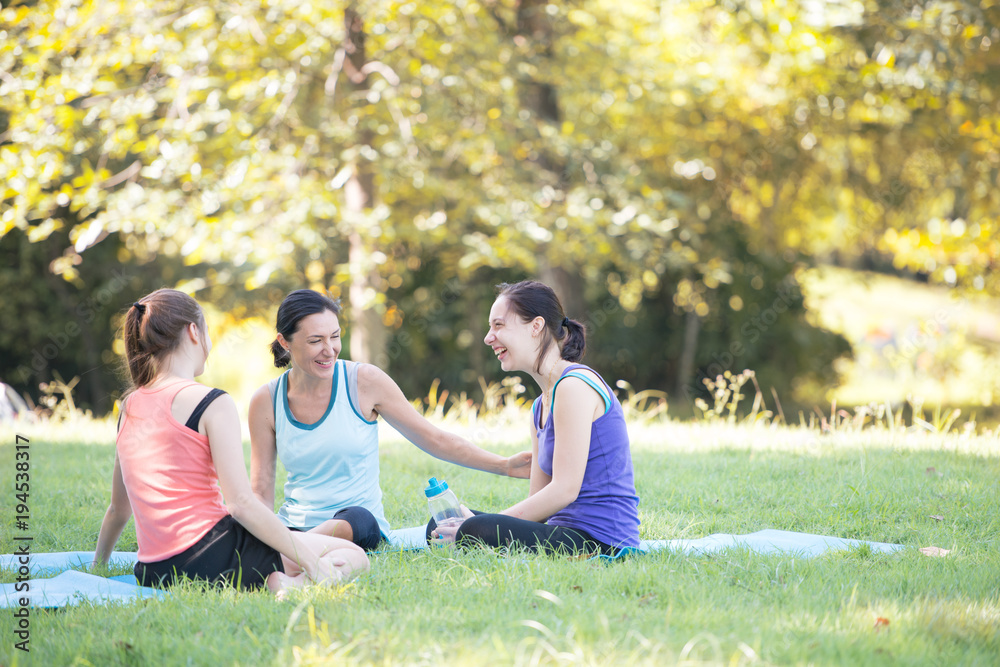 Families with young Russian mother and daughter are talk about exercise. After practice yoga at the park finished. Health and Fitness concept Families with young Russian mother and daughter are talk about exercise. After practice yoga at the park finished. Health and Fitness concept