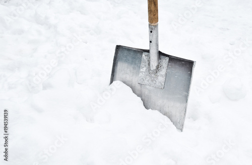 Snow shovel in a snowdrift. Copy space. photo