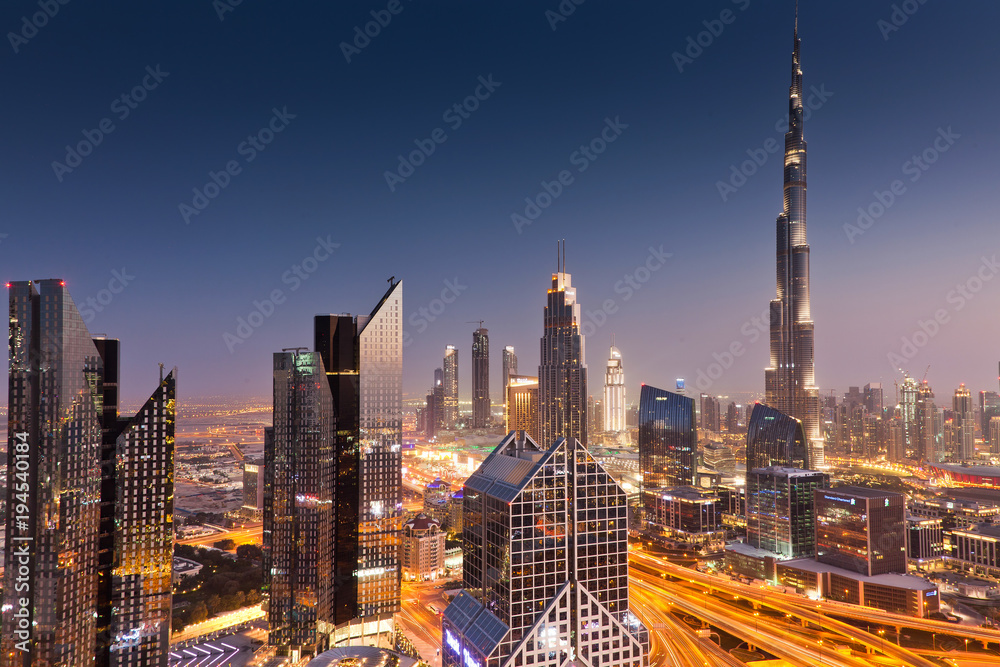 Naklejka premium DUBAI, UAE - FEBRUARY 2018: Dubai skyline at sunset with Burj Khalifa, the world tallest building and Sheikh Zayed road traffic